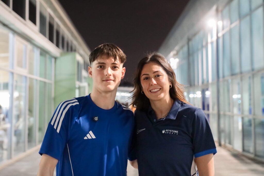 A member from sales with a student-athlete in a swimming competition.